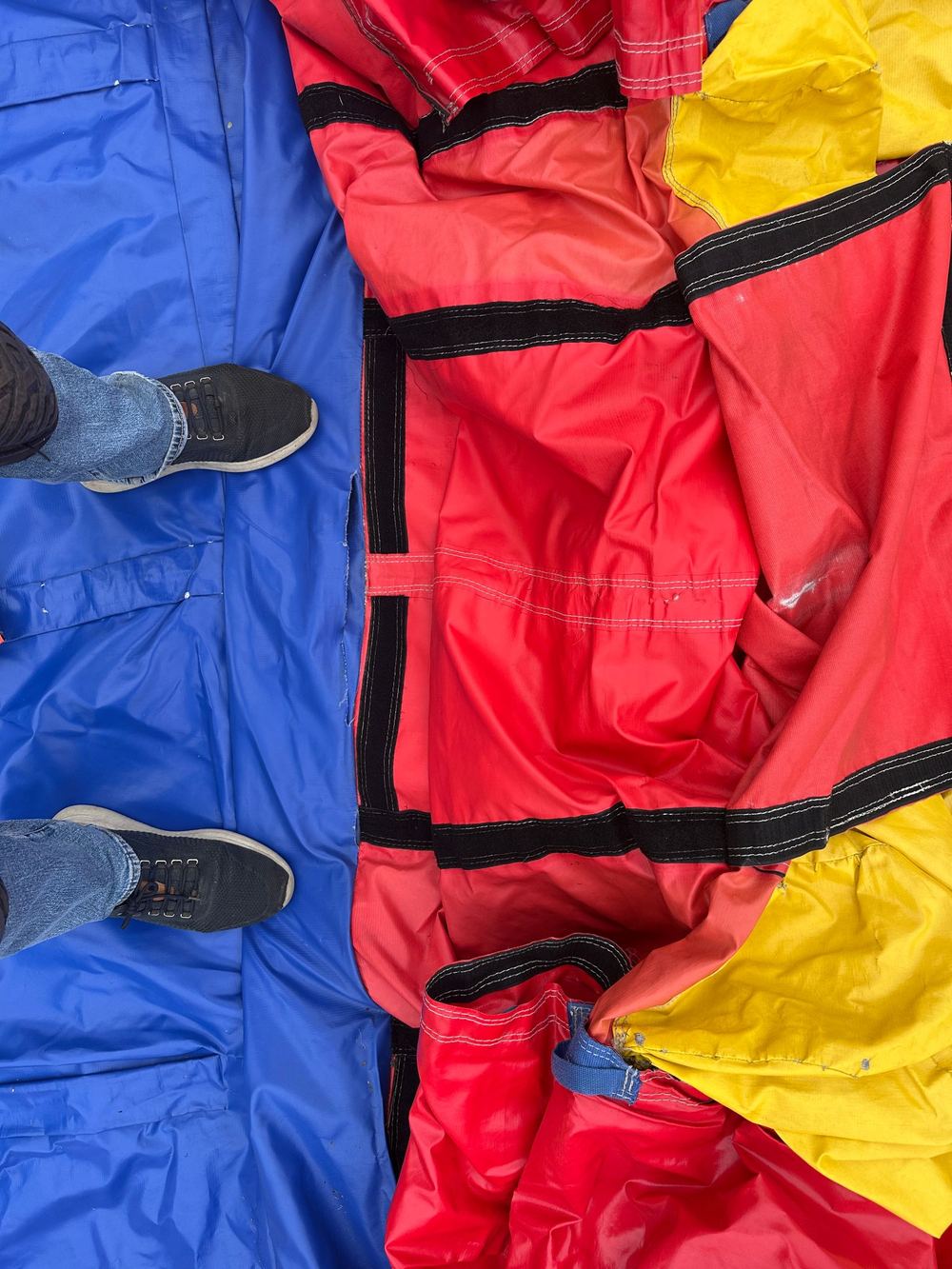 Before photo of a torn opening between panels exposing the velcro closure on a combo bounce house, completed by Stitches For Bounces