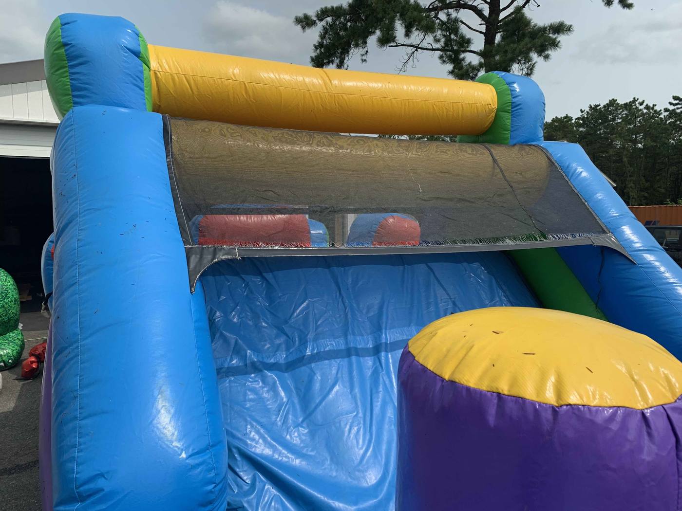 Before photo of safety netting repair on an inflatable unit, completed by Stitches For Bounces