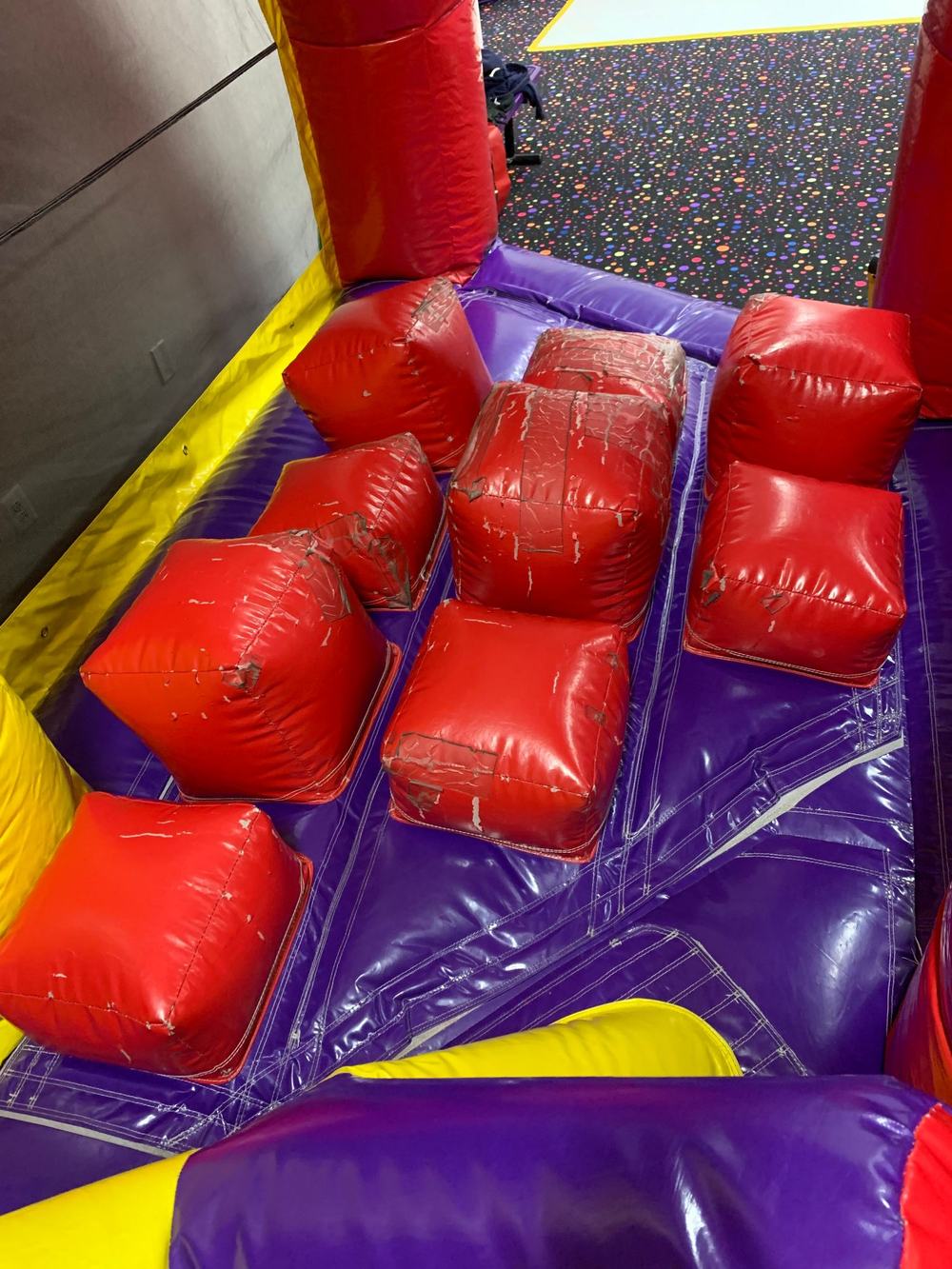 Before photo of a damaged inflatable pop-up obstacle inside an obstacle course, completed by Stitches For Bounces